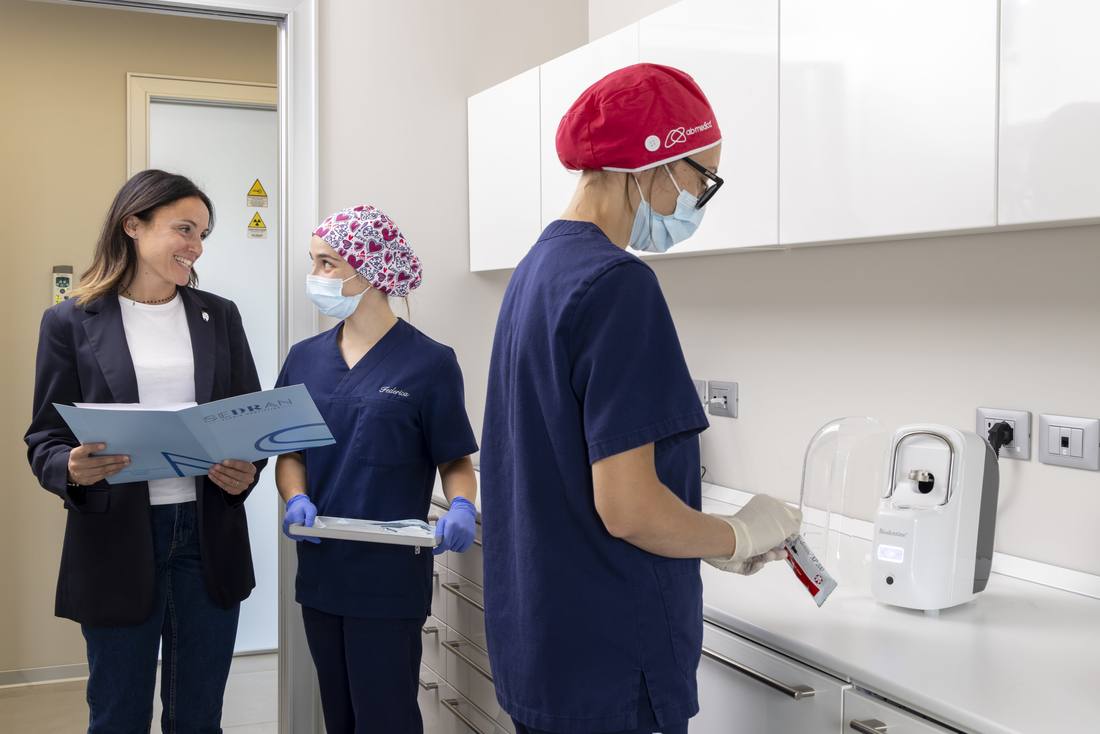 Due professioniste dello studio con un piano di cura e un'assistente in sterilizzazione