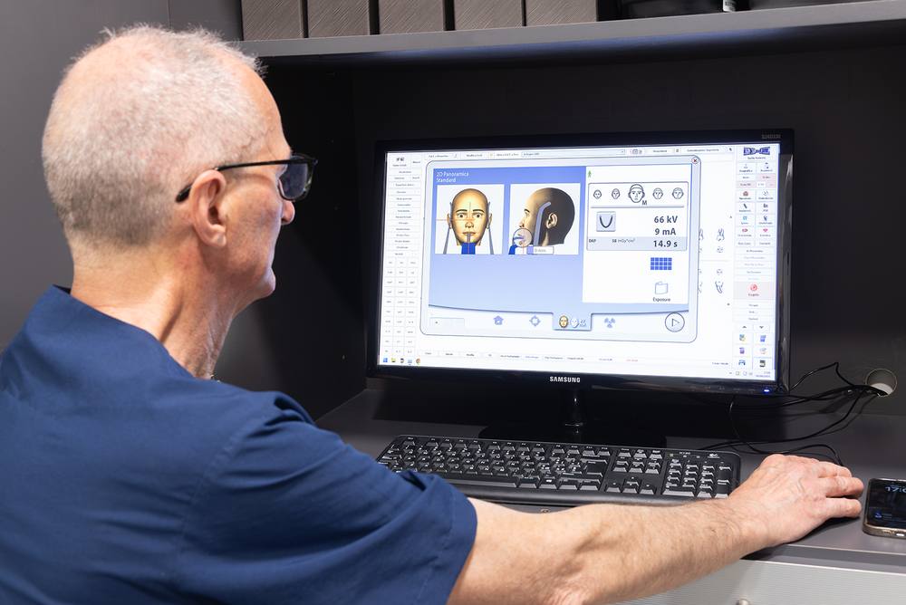 Un odontoiatra davanti al computer con le immagini digitali di una paziente