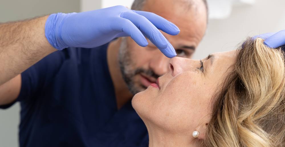 Un medico durante un trattamento estetico del volto