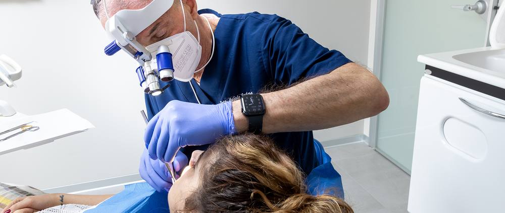 Un odontoiatra al lavoro con ingrandimento ottico