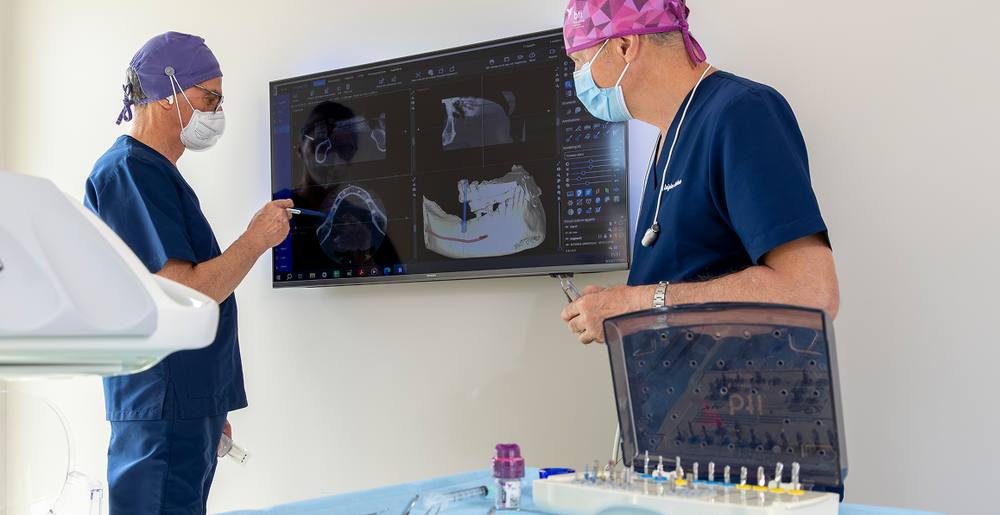 Un odontoiatra mostra una TAC su un grande schermo